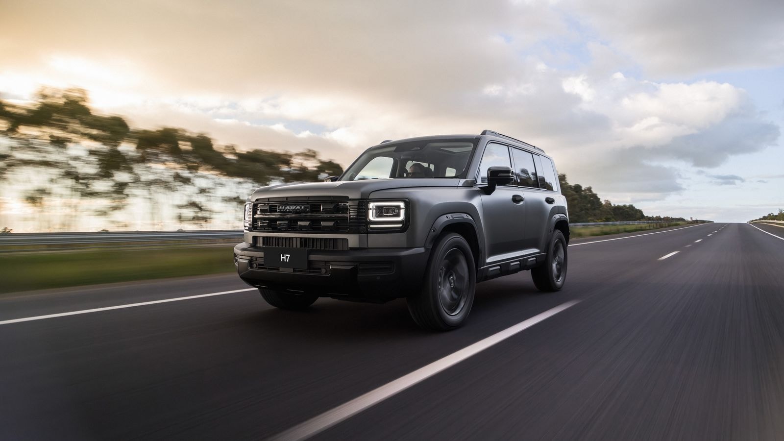 The new GWM Haval H7 SUV in matte grey driving on an open road